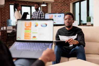 İş yerinde takım çalışması yapan iş arkadaşları, sunum ve çevrimiçi rapor oluşturmak için iş grafiklerini ve grafiklerini analiz ediyorlar. Dizüstü bilgisayarda şirket veri araştırma şemalarıyla çalışan insanlar.