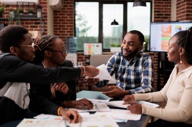 Meslektaşlardan oluşan bir ekip iş belgelerini başlangıçta inceliyor, şirket sunumunda takım çalışması yapmak için toplanıyor. Şirket raporunu planlamak için belgeler ve veri bilgileriyle çalışmak.