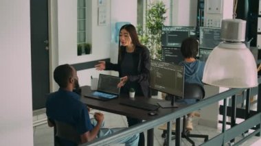 Uçbirim penceresindeki kaynak kodlar hakkında konuşan çeşitli kodlayıcılar, yeni arayüz oluşturmak için html betiği kullanıyorlar. Mühendisler algoritmaları çalıştırıyor, veritabanını kontrol ediyor, takım çalışması yapıyor..