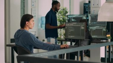 Veritabanı programcısı geliştirme ajansında kaynak kod ve bulut hesaplama geliştiriyor. Asyalı uygulama programcısı klavyede yazarak yapay zeka senaryosu yaratıyor. Üçayak atışı.