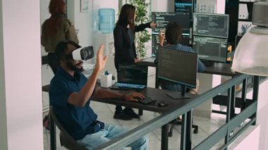 Yeni sunucu arayüzünü kodlamak için sanal gerçeklik gözlüğü kullanan erkek uygulama geliştiricisi, terminal penceresindeki bulut bilgisini analiz ediyor. Vr kulaklıklı internet yazılımı için kodlayıcı veritabanı programlıyor.