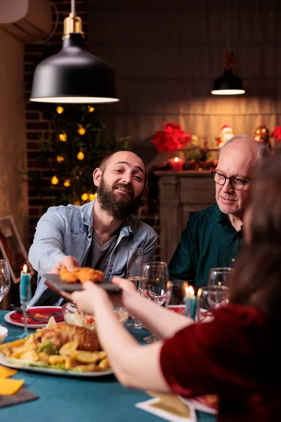 Familie Beim Festlichen Weihnachtsessen Essen Geschmückten Tisch Mann Reicht Teller — Stockfoto