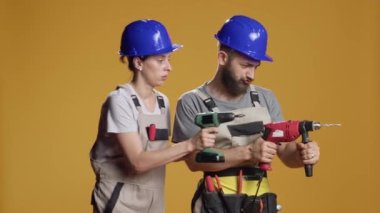Müteahhitlerden oluşan bir ekip çivi çakmak ve inşaat planı yapmak için elektrikli matkap makinesiyle çalışıyor. Dekonstrüksiyon ve yenilenme üzerinde çalışmak için matkap ya da çivi tabancası kullanılıyor..