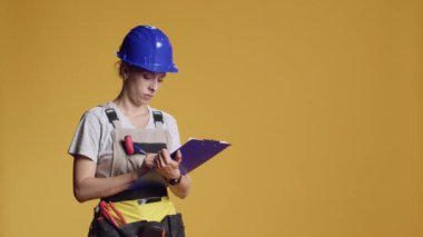 İnşaat işçisinin portresi not alıyor, mimari ölçümler yapıyor, yazı yazıyor ve pano kağıtlarına beyin fırtınası yapıyor. Kadın mimar yenileme projesi planlıyor..