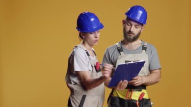 İnşaat işçilerinden oluşan bir ekip, yeniden geliştirmeyi ve hesaplama yapmak için beyin fırtınası yapmayı planlıyor. Mühendislik işi yapmak ve yenileme sürecini planlamak için kağıtlar hakkında notlar alıyorum..