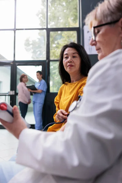 Yüksek Tansiyon Kan Basıncını Ölçen Kıdemli Doktor Hastane Bekleme Salonunda — Stok fotoğraf