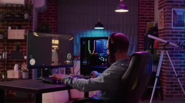 Man using pc gaming setup relaxing playing multiplayer online action game talking to team on headset in tournament. Gamer streaming first person shooter while explaining gameplay to subscribers.