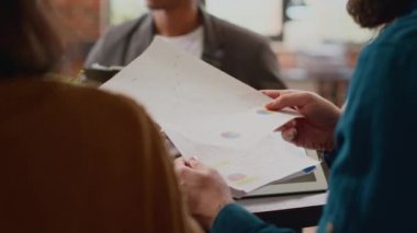 Dosyalardaki kurumsal bilgilere bakan iş adamları, belgeler ve dijital tablet üzerindeki veri araştırmalarını analiz ediyorlar. Ortaklık kurmayı planlayan iş arkadaşları bilgi sunumu ile çalışıyorlar. Kapat..