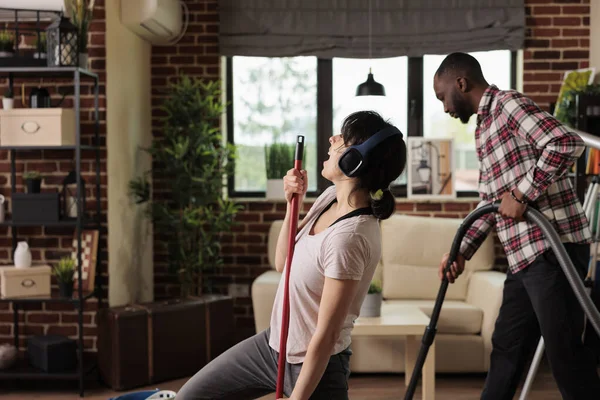 Wife Sings Headphones Using Mop Husband Charge Using Vacuum Cleaner — Stock Photo, Image
