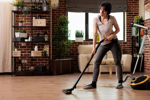 Modern Woman Using Vacuum Cleaner Listening Favorite Music Wireless Headphones — Stock Photo, Image