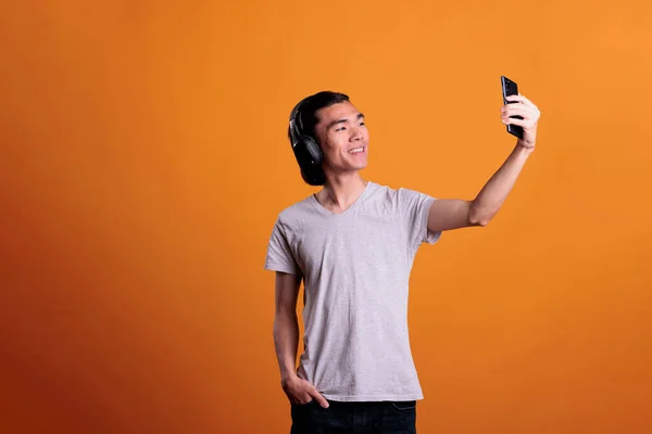 Uśmiechnięta Azjatycka Nastolatka Bezprzewodowych Słuchawkach Robiąca Selfie Przednią Kamerą Smartfona — Zdjęcie stockowe