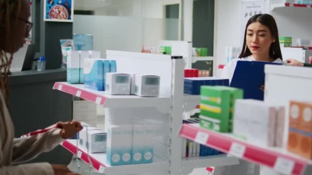 Азиатский Фармацевт Анализирует Коробки Добавок Полках Аптек Помочь Клиентам Лечением — стоковое видео