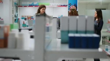 Çok ırklı bir grup insan NFC 'li akıllı sekip, kredi kartı ya da cep telefonu kullanarak eczane masasından ilaç ve takviye malzemesi alıyor. İlaç almak için eczane tezgahında ödeme yapmak.