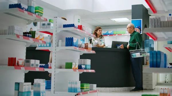 Starší Klient Mluví Lékárníkem Léčbě Pilulek Sedí Lékárny Přepážce Koupit — Stock fotografie