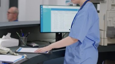 Sağlık sigortası ile sağlık hizmetleri randevuları üzerinde çalışan, sağlık raporları için doktora yardım eden bir doktor. Hemşire ve uzman danışma ve muayene hakkında konuşuyor..