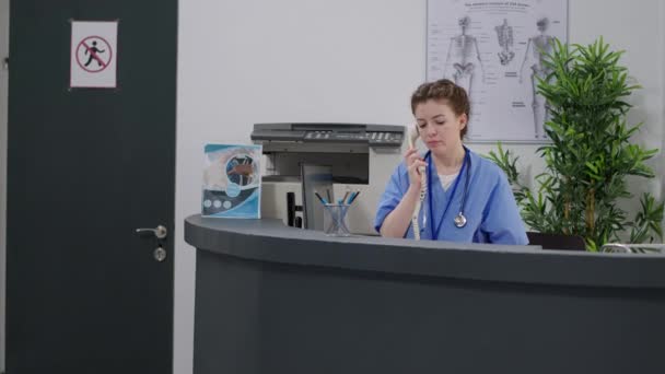 Medical Assistant Using Landline Phone Call Hospital Reception Desk Talking — Video