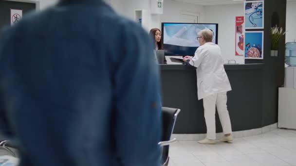 Азиатская Секретарша Работает Приёмной Больницы Помогает Доктору Назначениями Пациентами Медицинский — стоковое видео