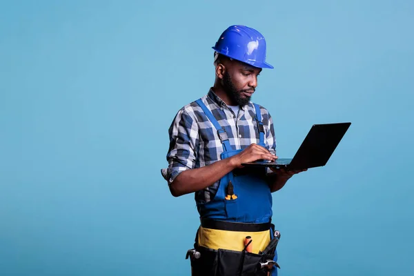 Concentrated Construction Worker Answering Emails Laptop Studio Shot Blue Background — Stock Photo, Image