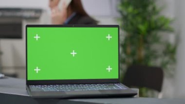 Laptop with greenscreen template at hospital reception desk used by medical staff. Using mockup background with isolated chroma key display and blank copyspace on monitor screen. Close up.