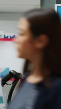 Dikey video: Eczaneden ilaç ve reçeteli ilaç almak için telefon ve NFC ödemelerini kullanan üst düzey bir müşteri. İlaçları ve ilaç şişelerini ödeyen yaşlı bir adam ilaç alıyor.