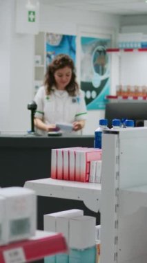 Dikey video: Afrikalı Amerikalı müşteriler tıbbi ürünler satın alıyorlar ve kredi kartıyla ödüyorlar, eczaneden ilaç almak için temas kurmadan ödeme yapıyorlar. İlaç almak için eczanede oturmak..