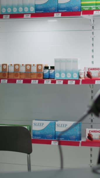 垂直ビデオ 病気のお客様を助けるために薬やビタミンの箱で満たされた空の薬局店 薬や薬 薬やヘルスケアのボトルのパッケージとドラッグストア棚 — ストック動画