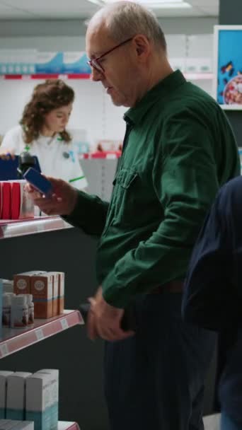 Κάθετη Βίντεο Senior Man Taking Box Pills Pharmacy Reports Buy — Αρχείο Βίντεο