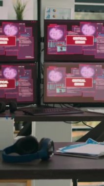 Dikey video: Bilgisayarlı monitörlü boş ofis, sistem hatasını gösteriyor ve güvenlik ihlali uyarısı gösteriyor. Kritik hata iletisi yanıp sönen ekranlar, hacklenen sunucu.