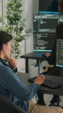 Dikey video: Asyalı yazılım mühendisi sunucu kodlu güvenlik programı üzerinde çalışıyor, bilgisayar ekranında sistem bilgileri yazıyor. Veritabanı programcısı algoritmalarla kod yazıyor, o dil.