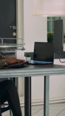 Dikey video: Tekerlekli sandalyedeki bulut programcısı, sunucu verilerini kullanarak bilgisayardaki yazılım uygulamasını yaratıyor ve kronik sakatlık yaşıyor. Ajans ofisinde yeniden kullanım arayüzü geliştirme üzerinde çalışan kodlayıcı