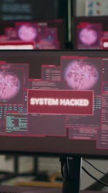 Dikey video: Ekranlarda güvenlik ihlali ve kritik hata mesajı gösteren monitörlü boş kodlama ofisi. Masada hackleme saldırısı ve arıza gösteren birden fazla bilgisayar var..
