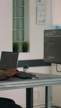 Dikey video: Terminal pencereye kaynak kod ve betik yazan veritabanı programcısı, bilgisayar görüntüleme algoritması ile çalışıyor. Yazılım geliştiricisi ajans ofisinde büyük veriler programlıyor.