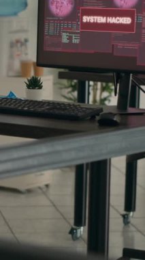 Dikey video: Boş programlama ofisinde bilgisayar arızası ve güvenlik ihlali gösteren birden fazla monitör. Ekranda kritik hata mesajı gösteren bilgisayarlar ve masadaki sistem çökmesi.