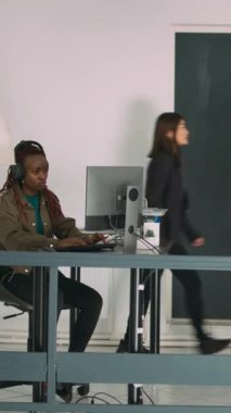Dikey video: Kıdemli geliştiriciler yazılım ajansı ofisinde dizüstü bilgisayarda kodlama yapıyor, kodları ayrıştırıyor ve dil geliştiriyorlar. Ekip yenilikçi makine öğrenme algoritmaları ve güvenlik duvarı sunucusu kullanıyor.