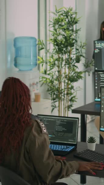 垂直ビデオ コンピュータの前でコーディングスクリプトについて話しているAiクラウドプログラマーの多様なチームは サーバーインターフェイスの開発に取り組んでいます Htmlソフトウェア言語を計画するためにチームワークを行うプログラマー — ストック動画