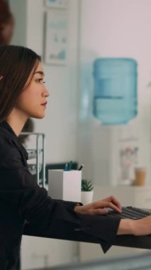 Dikey video: Asyalı programcı html betiği kullanarak uygulama geliştirme programı üzerinde çalışmak için bilgisayarda büyük veri kodları yazıyor. IT sistem mühendisi ai algoritması yazıyor ve başlangıç şirketinde masa başında oturuyor.