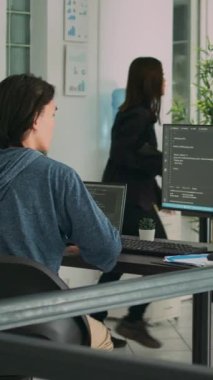 Dikey video: Asyalı betik programcısı yeni arayüz kodu kullanmak için veritabanı bilgileriyle çalışıyor. html dili verileri yazan yazılım geliştiricisi, geliştirme ajansı ofisinde güvenlik uygulaması planlıyor