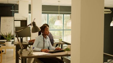 İş raporu ve araştırma sunumu üzerinde çalıştıktan sonra iş yerinden birlikte ayrılan Afrikalı Amerikalı meslektaşlar. Erkek ve kadın gün batımında şirket işlerini bitiriyor..