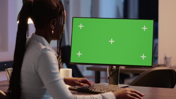 モニタ上の緑の画面の表示を分析する会社の労働者は ビジネスオフィスで孤立した画面を見て モックアップ背景とクロマキーを持つ空白のコピースペーステンプレートを使用します 三脚ショット — ストック動画