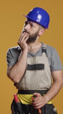 Dikey video: Yeniden yapılanma, yenileme çözümü ve karar üzerinde kafa yorma üzerinde çalışmak için beyin fırtınası yapan inşaat işçisi. Şüphe giderme hakkında düşünen dalgın bir adam..