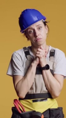 Dikey video: Kadın müteahhitin portresi servet istemek için dua ediyor, yenileme ve onarım üzerinde çalışıyor. Dua eden eller umuda işaret eder ve güven ister, inançlı ve dindar olur..