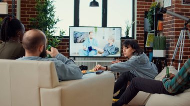 Televizyonda aksiyon filmi seyreden, bira içen ve televizyon dizisi ya da film izleyen bir grup arkadaş. Sinema programı, içkiler, atıştırmalıklar, boş zaman aktiviteleri....