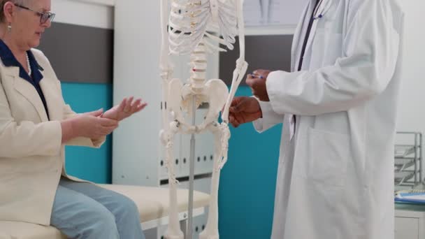 Physician Examining Human Skeleton Cabinet Checkup Visit Explaining Anatomy Bones — Stock Video