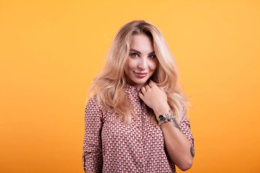 Studio sarı arka plan üzerinde kısa elbiseli güzel sarışın