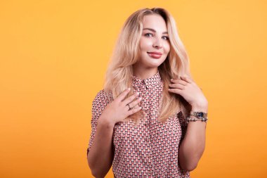 Studio sarı arka plan üzerinde kısa elbiseli güzel sarışın