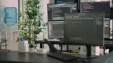 Sunucu kodu ve programlama dilini gösteren, yazılım geliştirme bürosunda derleyen birden fazla monitörü olan boş bir masa. Sistem bulut hesaplama çevrimiçi veritabanı algoritmaları.