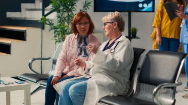 Tesis lobisindeki röntgen taramasına bakan uzman ve Asyalı hasta bekleme alanında tıbbi hastalık teşhisi koyuyor. Kontrol ziyareti randevusunda radyografi sınavının sonucu analiz ediliyor.