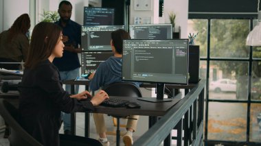 Yeni güvenlik duvarı ve html betiği geliştirmek için bilgisayar ekranında kullanıcı arayüzü ile çalışan Asyalı yazılım mühendisi. Veritabanı programcısı terminal penceresinde sunucu algoritmaları ile kod yazıyor.