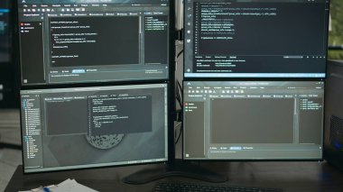 Masasında bilgisayar ekranları olan boş bir veri odası, arka planda çalışan bilgisayarlar programlama kodu ve terminal penceresinde algoritmalar. Ajans ofisindeki Firewall ağ sunucuları.