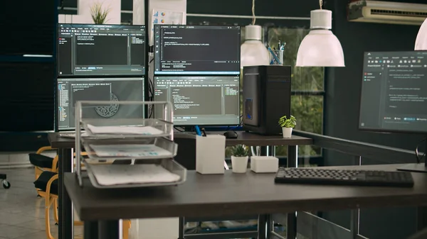 Computer monitors showing parsing code in empty it agency office, security system compiling data algorithms in background. Artificial intelligence servers cloud computing in data room.